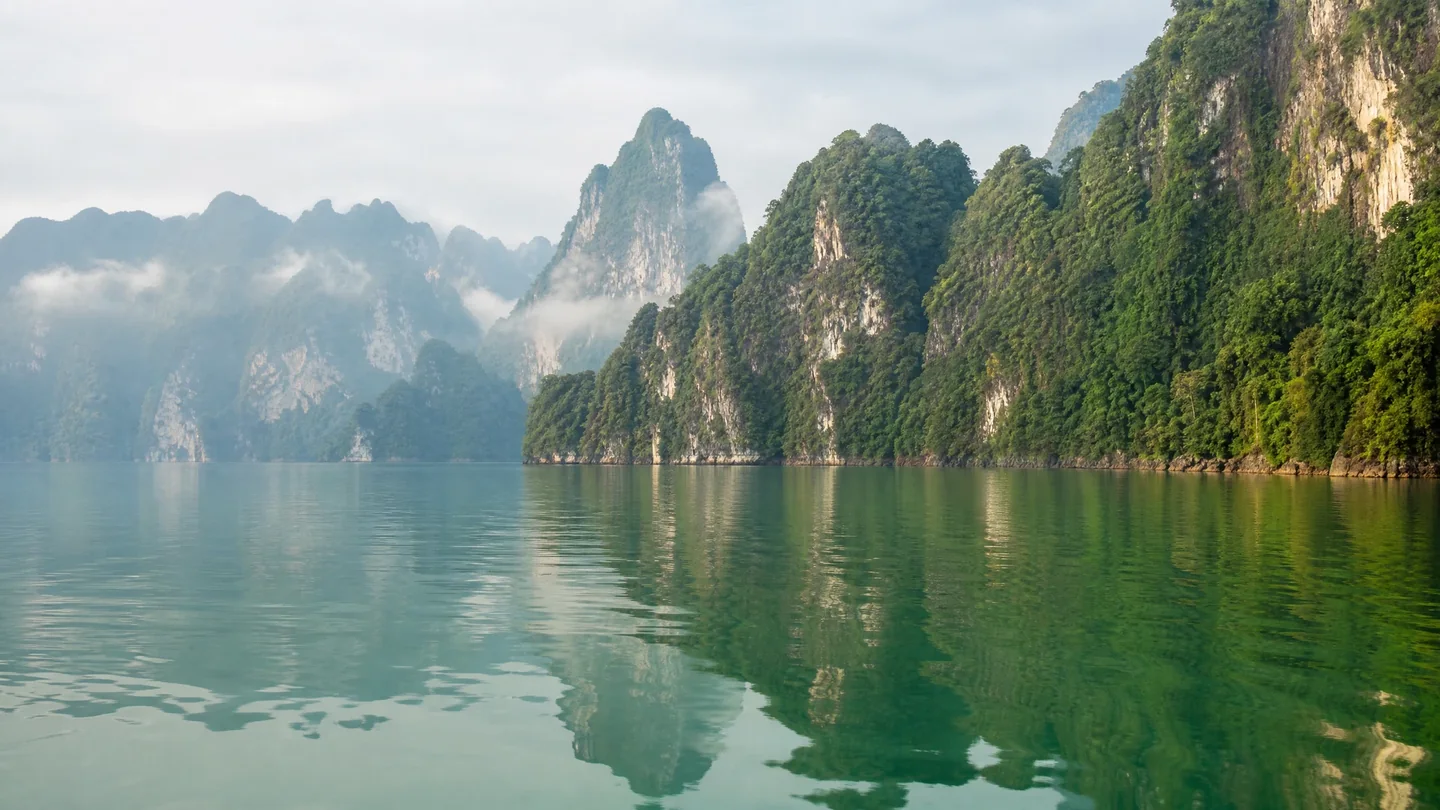 Cover image for The emerald heart of Thailand beats within the ancient limestone cathedrals of Khao Sok.