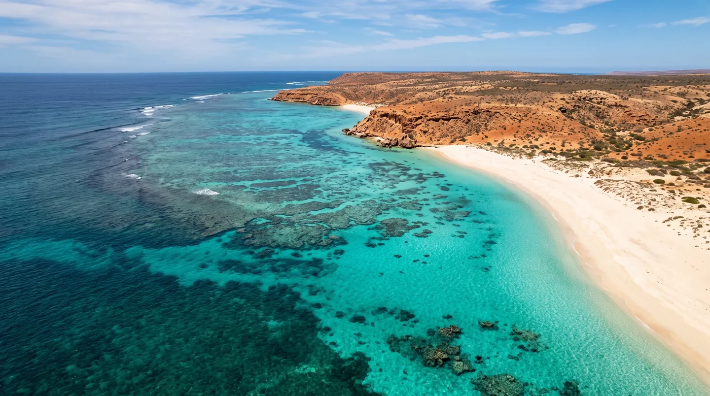 Cover image for Where the crimson desert bleeds into a turquoise sanctuary of ancient coral gardens.